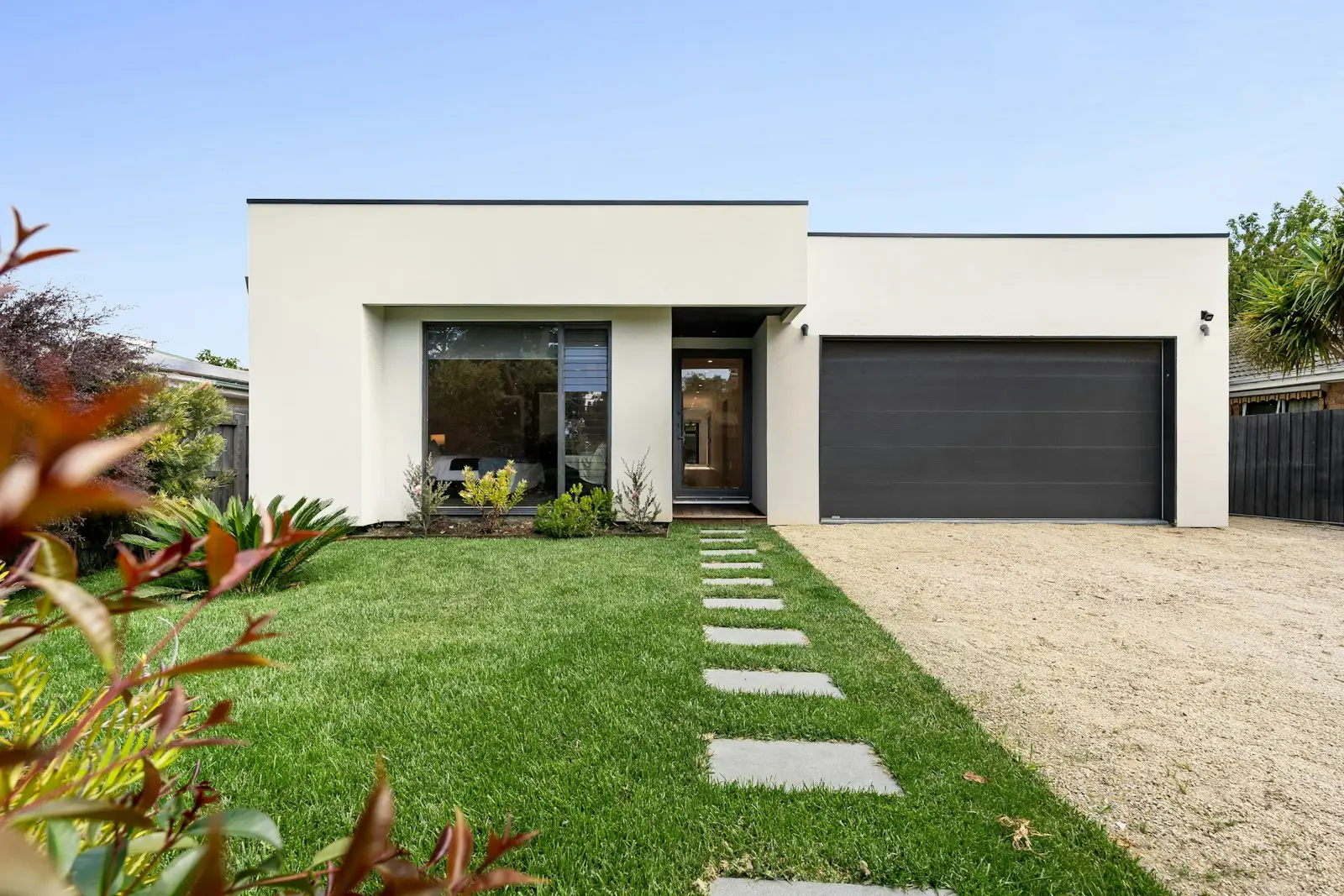 Modern single-story home with a charcoal flush garage door